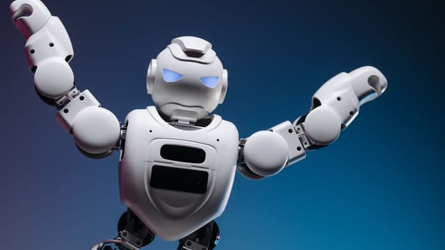 A futuristic robot in a studio setting, striking a powerful pose with raised arms.