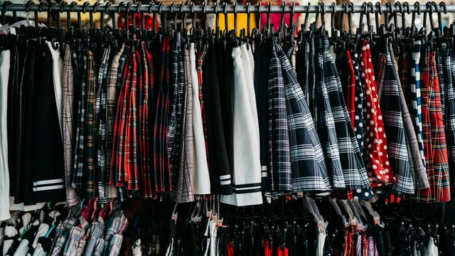 Vibrant selection of skirts and clothing hanging on a retail store rack.
