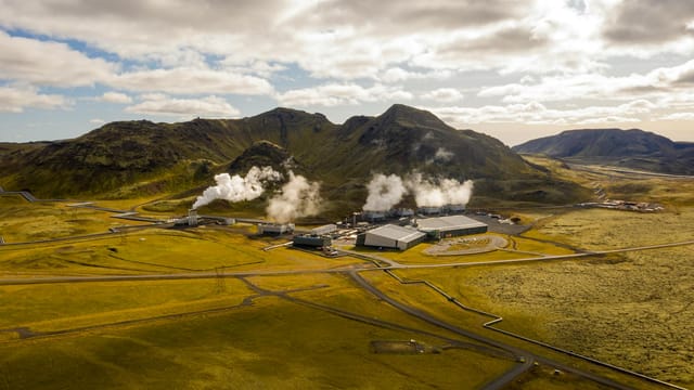 Aerial view of Hellisheidi geothermal power plant with mountains and steam in Iceland