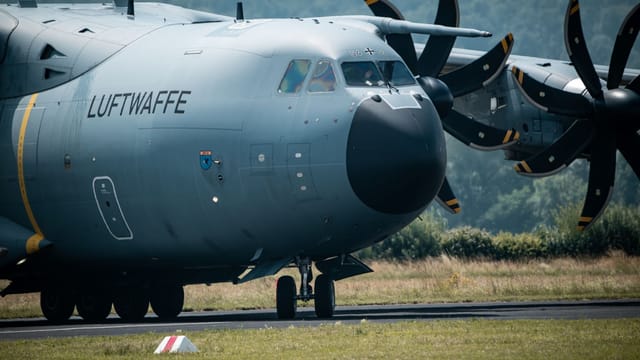 A close-up view of a German Luftwaffe A400M aircraft on the runway, ready for take-off.