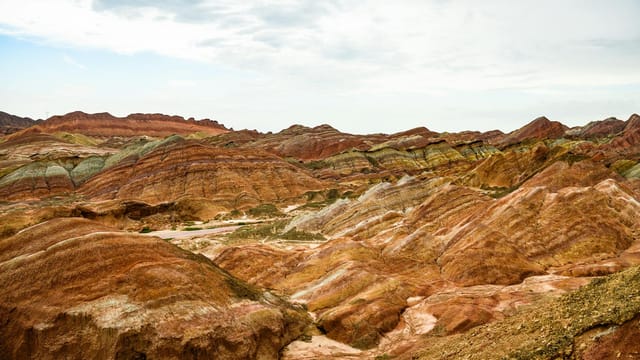 Vibrant Danxia landform landscape in Gansu Province, showcasing striking multicolored rock formations.