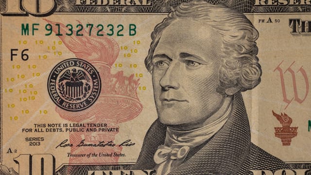 Detailed close-up image of a US ten dollar bill with Alexander Hamilton's portrait.