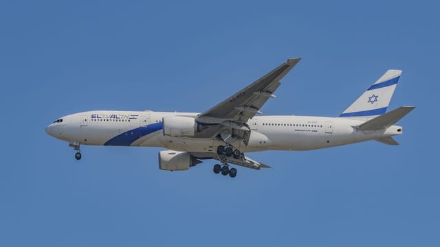 El Al Boeing 777 aircraft flying through a clear blue sky, capturing aviation in motion.