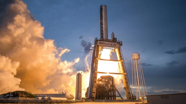A dramatic shot of a SpaceX rocket launch against a colorful dusk sky, depicting power and technology.