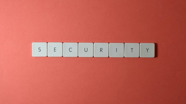 A conceptual image of the word 'security' spelled with keyboard keys on a red surface, providing copy space.