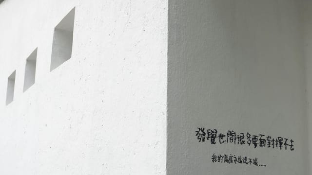 Minimalist white wall with geometric design and Chinese text in Hong Kong.