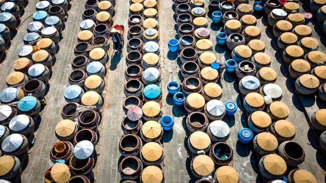 Aerial shot showcasing rows of traditional fermentation jars in a Chinese setting.