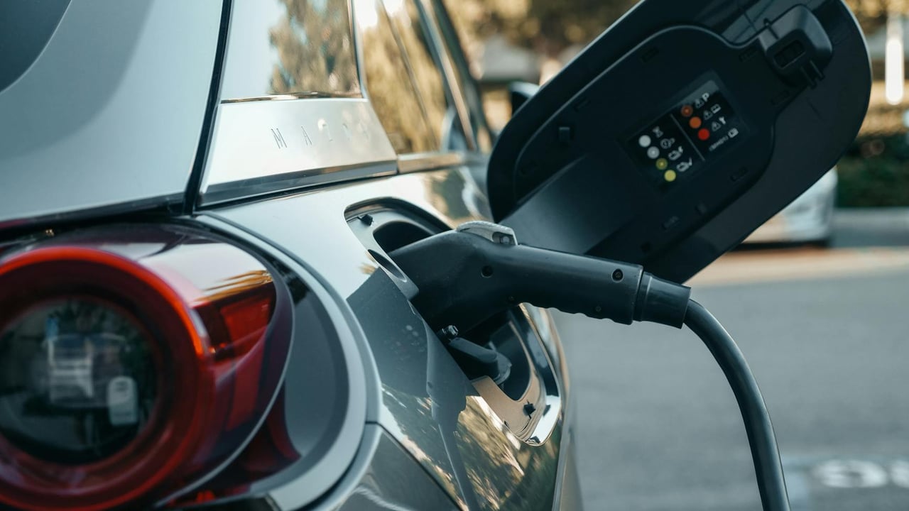 Close-up of an electric vehicle being charged, highlighting modern clean energy technology.