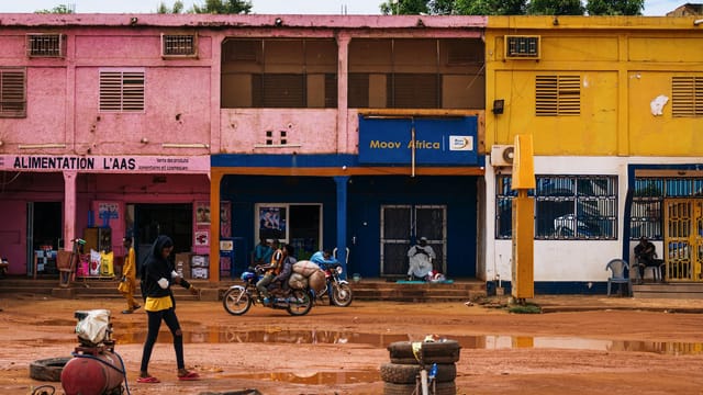 Vibrant city street in Africa with colorful buildings and local activity.