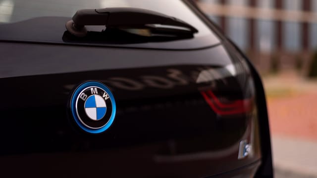 Close-up of black BMW car with logo, offering modern sleek design.