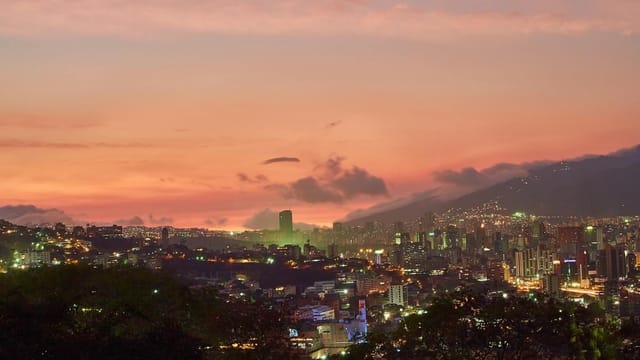 A breathtaking view of Caracas skyline at twilight with a vivid sunset backdrop.