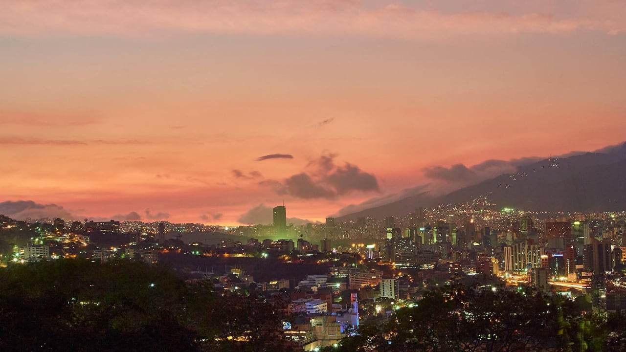 A breathtaking view of Caracas skyline at twilight with a vivid sunset backdrop.
