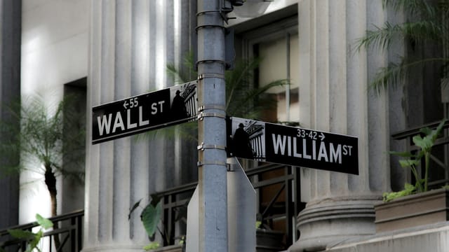 Intersection of Wall Street and William Street, showcasing iconic financial district signage in New York City.
