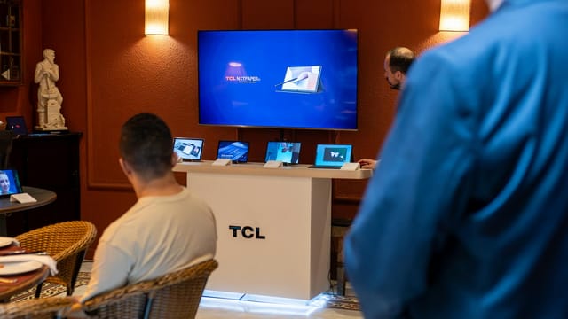 A professional business presentation showcasing new, sleek tablets and technology in a modern showroom setting.