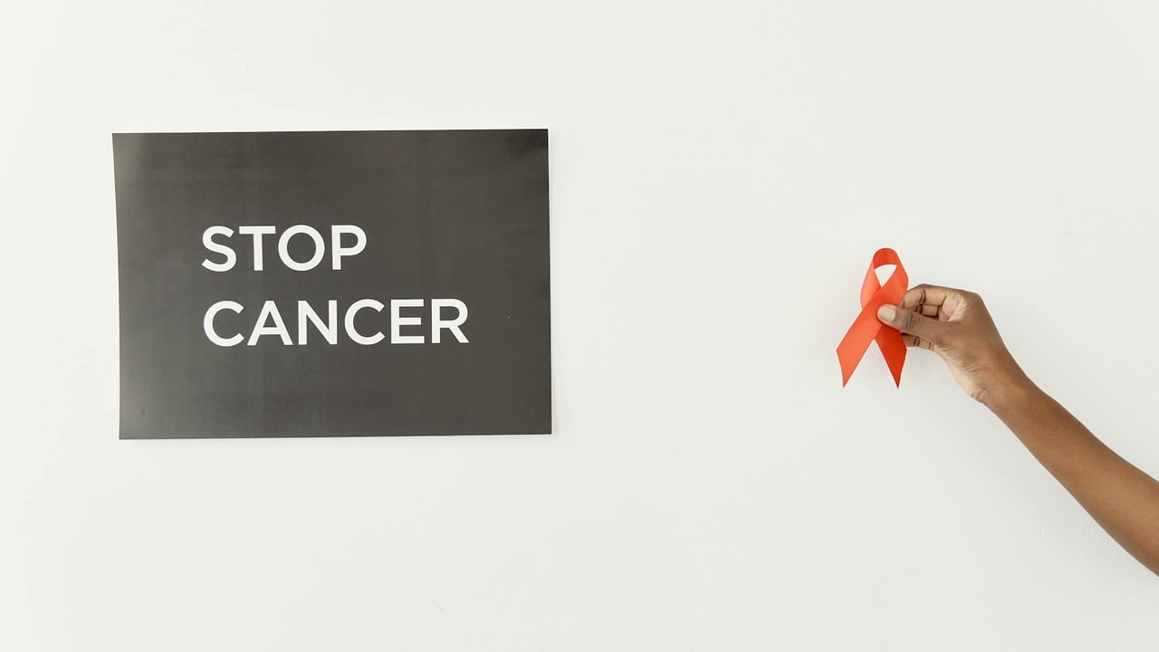 Powerful image advocating cancer awareness featuring a red ribbon and 'Stop Cancer' message.