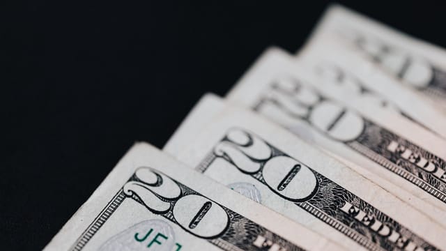 Closeup of USA 20 dollar bills placed on black surface as national currency for business and personal financial operations