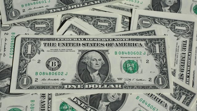 A detailed shot of a pile of U.S. one-dollar bills showcasing currency and finance concepts.