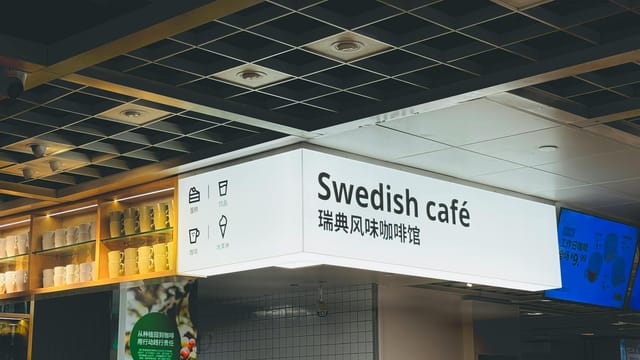 Interior of a Swedish café in Tianjin, China, featuring illuminated sign and modern decor.