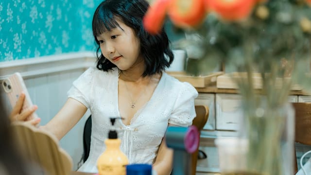 A young woman takes a selfie in a cozy and decorated room, creating a cheerful and relaxed atmosphere.