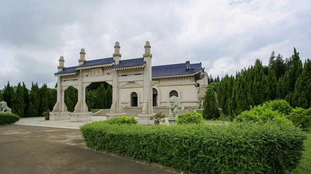 Majestic gate of the Sun Yat-sen Mausoleum surrounded by lush greenery in Nanjing, China.