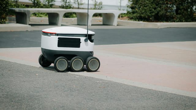 A modern autonomous delivery robot navigating an urban environment. Innovative technology for food delivery.