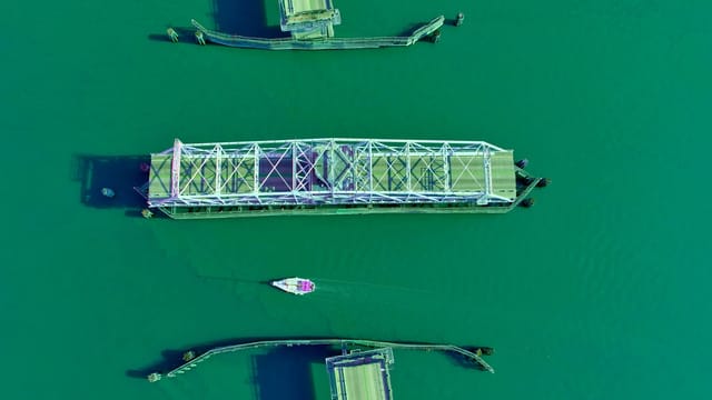 A stunning aerial view of the drawbridge in Beaufort, SC, spanning a vibrant green river.