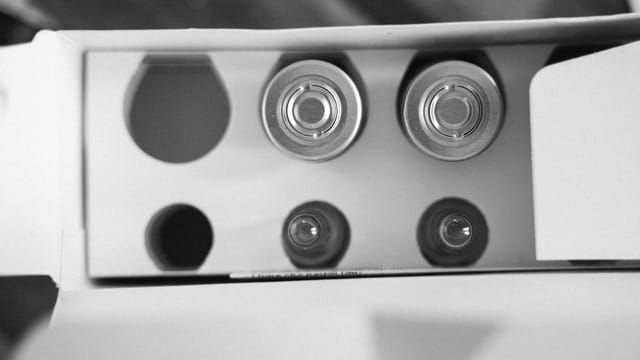 Top view of open battery packaging in black and white, showcasing round cells.