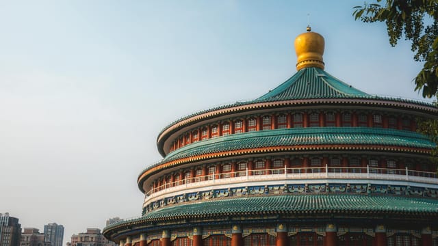 Stunning shot of Chongqing People's Hall showcasing traditional Chinese architecture against cityscape.