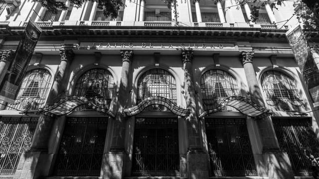 Black and white view of Teatro de la Ciudad in Mexico City highlighting architectural details and shadows.