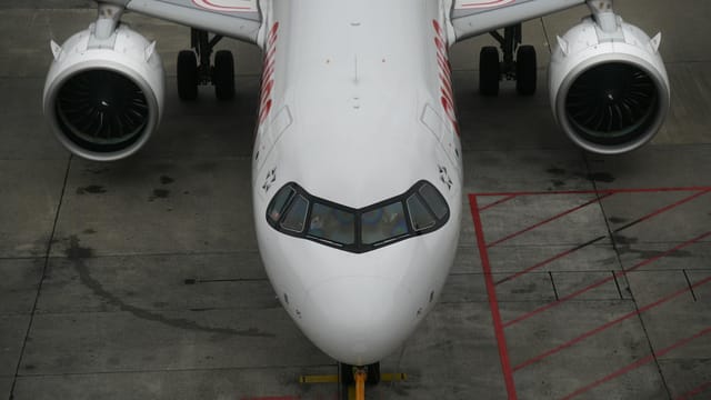 Aerial shot of an Airbus aircraft on the runway, showcasing its engines and cockpit from above.