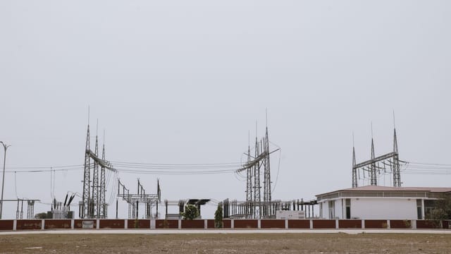 An industrial power station under a clear sky, showcasing electrical infrastructure and technology.