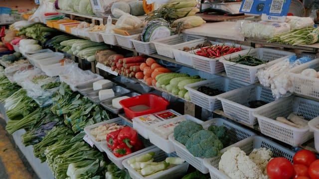 Colorful assortment of fresh vegetables at an outdoor market stall.