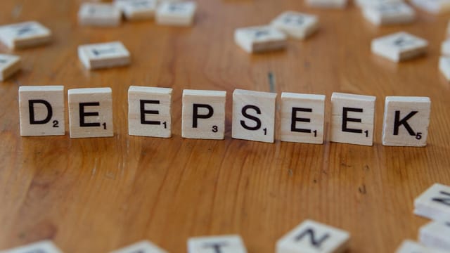 Scrabble tiles spelling 'DeepSeek' on a wooden surface. Perfect for AI and tech themes.
