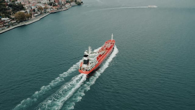 Aerial shot of a red cargo ship navigating the Bosphorus Strait near Istanbul, Turkey.