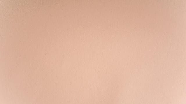 A seamless and smooth pastel pink wall texture perfect for backgrounds and design projects.