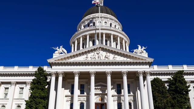 Sunlit view of the California State Capitol with clear blue skies.