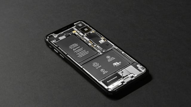 High-resolution image of a smartphone showcasing its internal components on a dark surface.