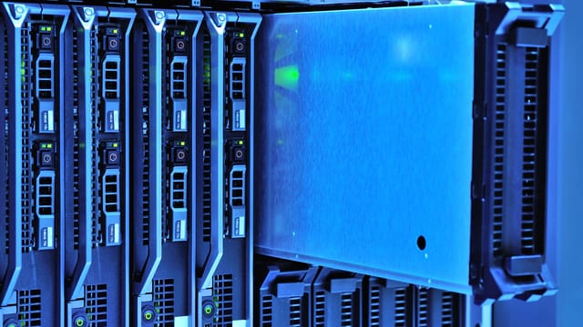 Illustrative image: Detailed view of server racks with glowing lights in a data center environment.