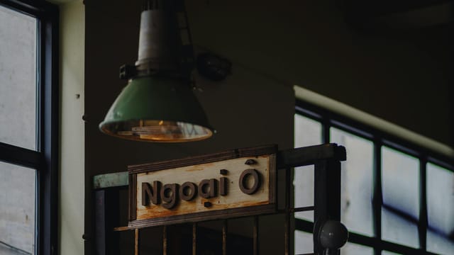 Vintage industrial design with hanging lamp and wooden sign indoors.