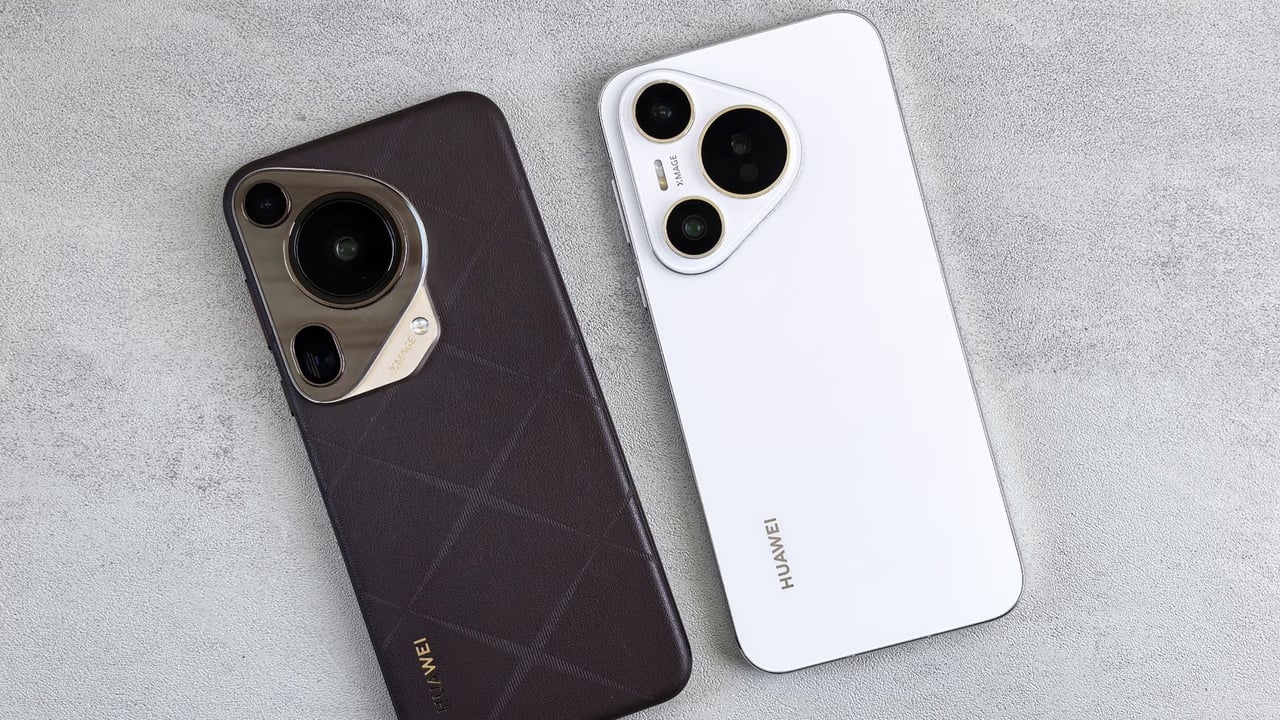Top view of two Huawei smartphones, one black and one white, on a concrete surface.