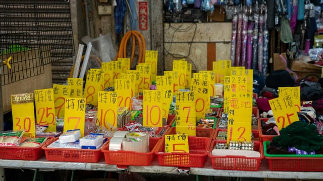 Explore a lively market stall displaying a range of goods with bold sales tags.