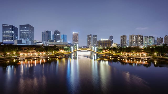 Illuminated skyline and reflections along the river in Foshan, China at night.