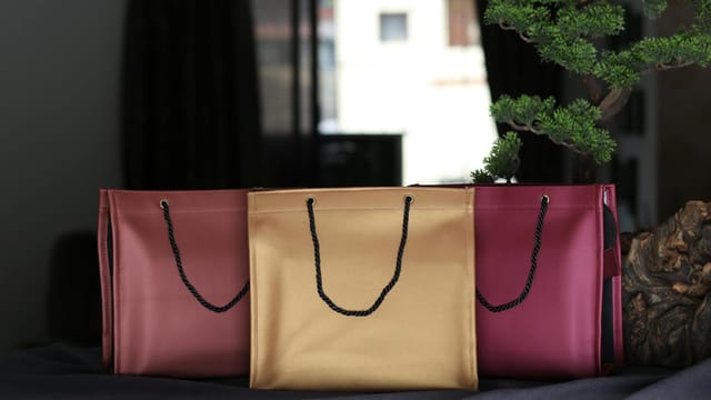 Luxurious leather shopping bags in rich colors elegantly arranged indoors.