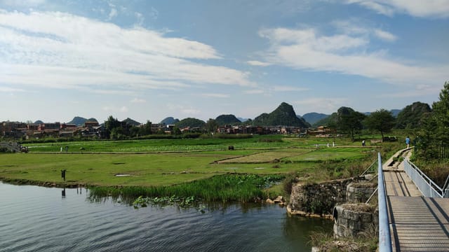 Idyllic rural landscape in Wenshan, China with lush fields and a serene lake.