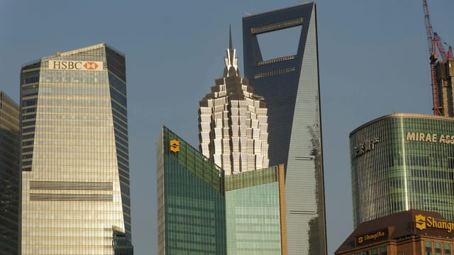 Iconic skyscrapers towering in Pudong, Shanghai under a clear blue sky.