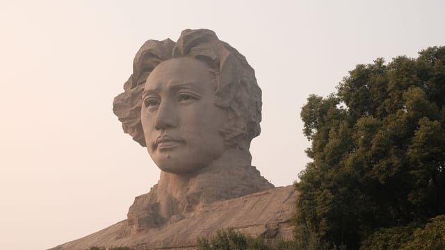 Impressive Mao Zedong statue in Orange Isle park, China surrounded by greenery.