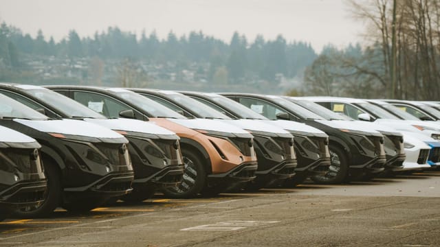 Rows of sleek electric cars parked outdoors, showcasing automotive design and innovation.