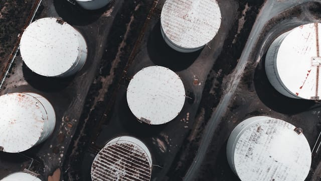 Drone shot showcasing large industrial storage tanks from above.