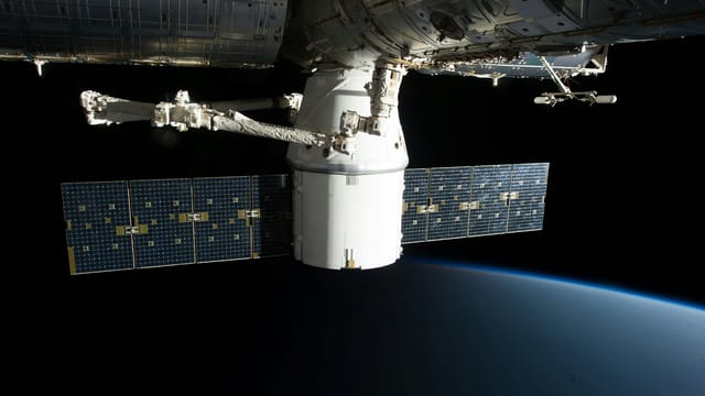 Image of the International Space Station floating above Earth with visible solar panels.