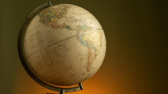A vintage globe illuminated with warm lighting, showcasing the Americas.
